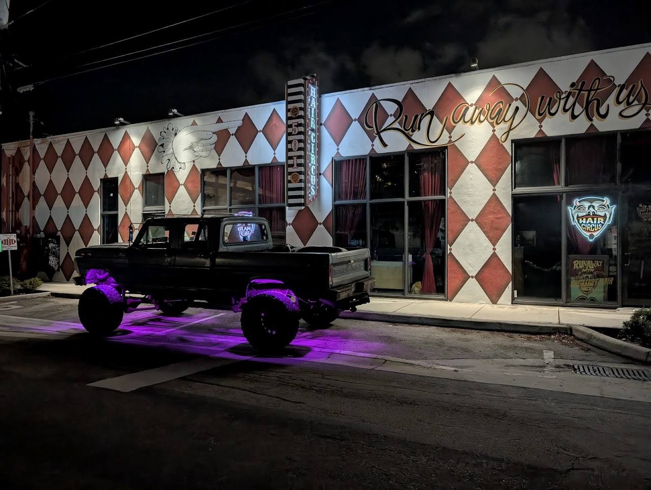 Hair Circus salon storefront at night